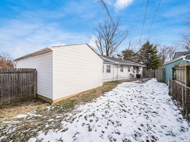 snow covered house featuring central AC