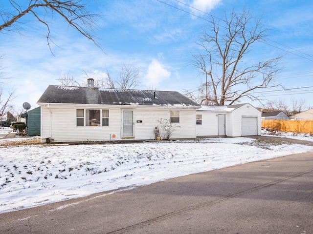 ranch-style house featuring a garage and an outbuilding