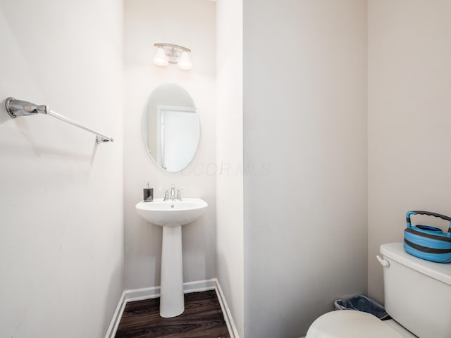 bathroom with hardwood / wood-style flooring and toilet