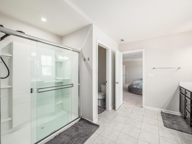 bathroom with toilet, an enclosed shower, a textured ceiling, tile patterned floors, and vanity