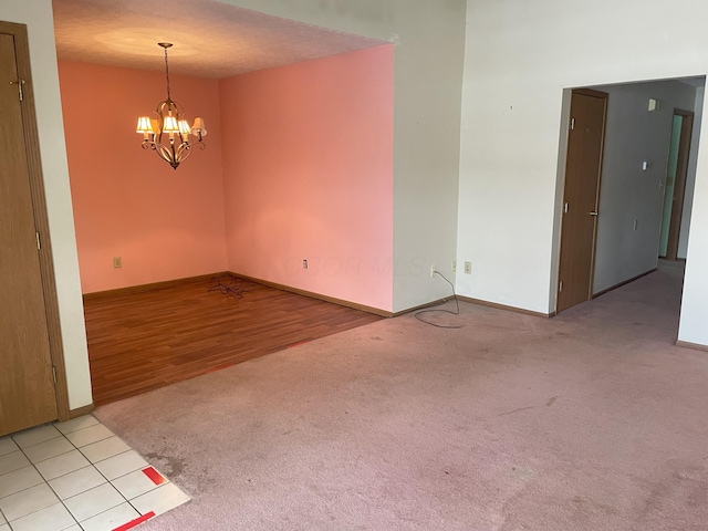 tiled empty room featuring a chandelier