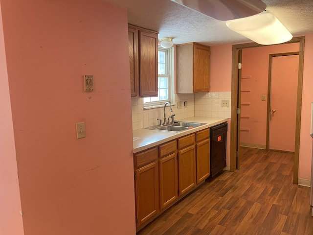 kitchen with dishwasher, sink, dark wood-type flooring, a textured ceiling, and decorative backsplash