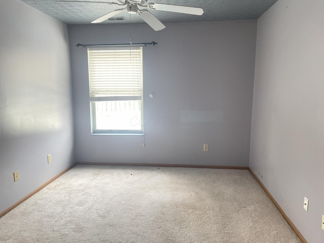 carpeted empty room with ceiling fan and a textured ceiling