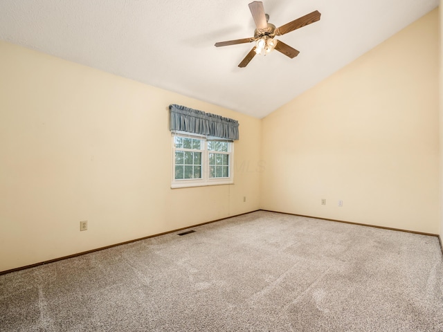 carpeted empty room with vaulted ceiling and ceiling fan