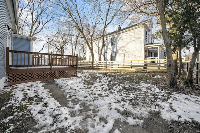 snowy yard featuring a deck