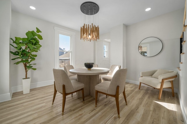 dining space with a chandelier and light hardwood / wood-style flooring