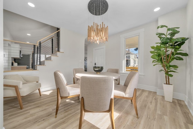 dining space with light wood-type flooring and a chandelier