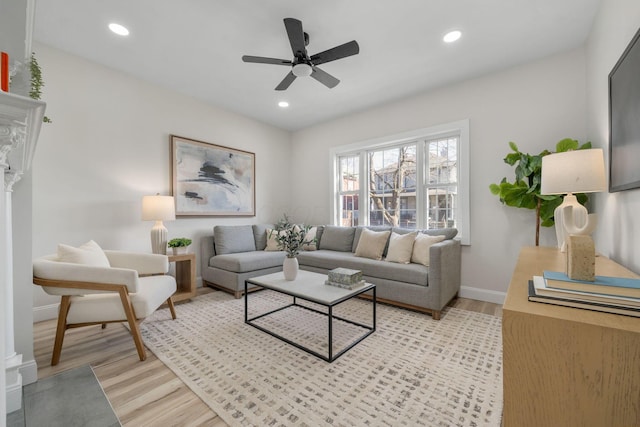 living room featuring ceiling fan and light hardwood / wood-style floors