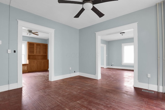 unfurnished room with dark wood-type flooring and ceiling fan