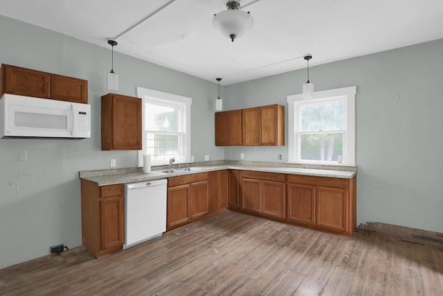 kitchen featuring pendant lighting, sink, white appliances, and a healthy amount of sunlight