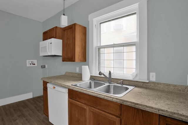 kitchen with sink, white appliances, hanging light fixtures, and dark hardwood / wood-style flooring