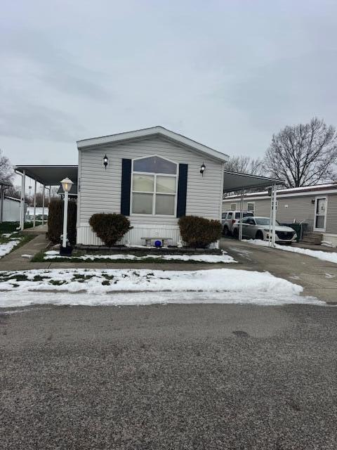 view of snow covered exterior featuring a carport