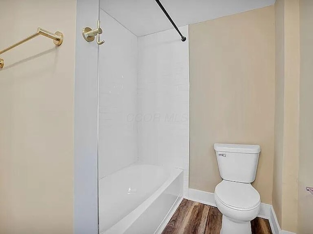 bathroom with wood-type flooring, toilet, and shower / washtub combination