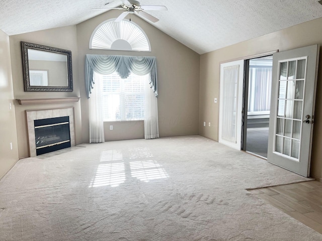 unfurnished living room with carpet floors, a fireplace, a textured ceiling, and vaulted ceiling