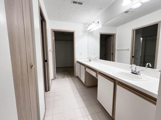 bathroom featuring vanity, tile patterned flooring, and a textured ceiling