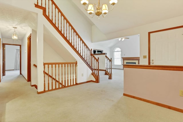 stairs featuring carpet, lofted ceiling, and a chandelier