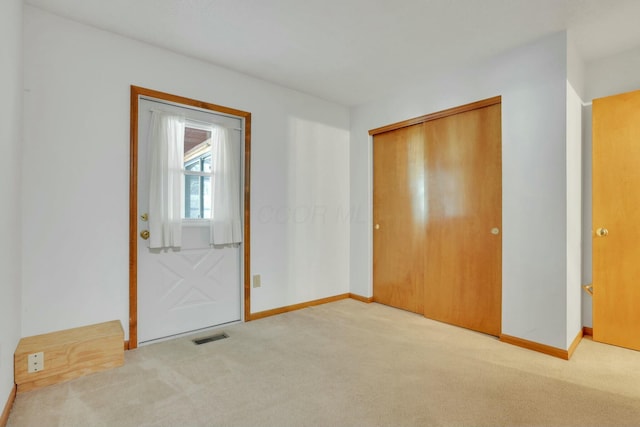 interior space featuring light carpet and a closet