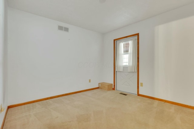 unfurnished room featuring light carpet