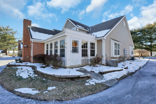 view of snow covered exterior featuring central AC unit