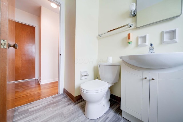 bathroom featuring hardwood / wood-style flooring, toilet, and vanity