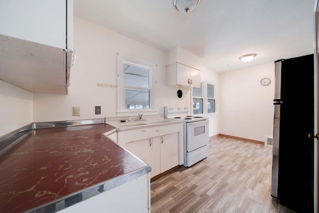 kitchen featuring white cabinetry, stainless steel refrigerator, white electric range oven, light wood-type flooring, and sink