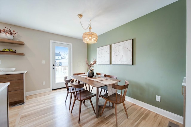 dining space with an inviting chandelier and light wood-type flooring