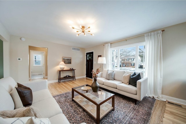 living room featuring hardwood / wood-style flooring and an inviting chandelier