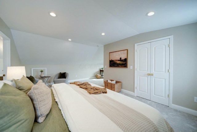 bedroom with lofted ceiling, carpet, and a closet