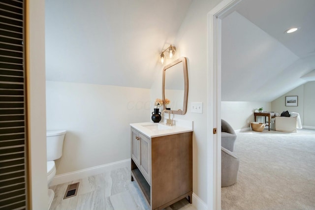 bathroom featuring lofted ceiling, toilet, and vanity