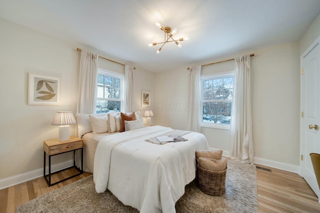 bedroom featuring a notable chandelier and light hardwood / wood-style flooring