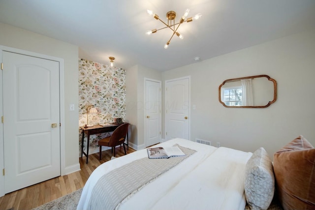 bedroom featuring hardwood / wood-style flooring and an inviting chandelier