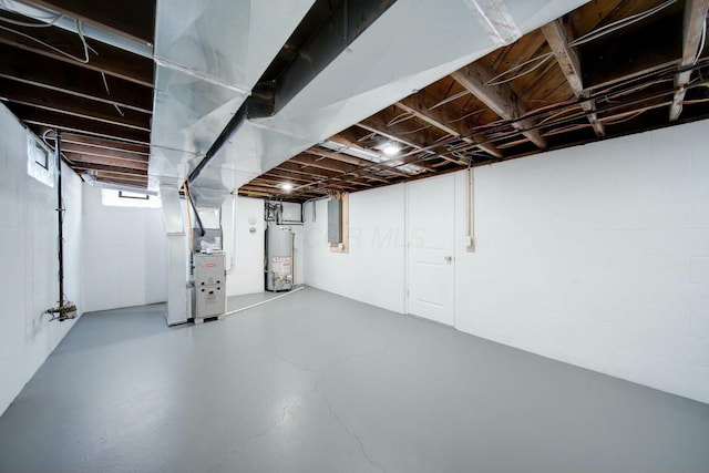 basement featuring heating unit, electric panel, and water heater