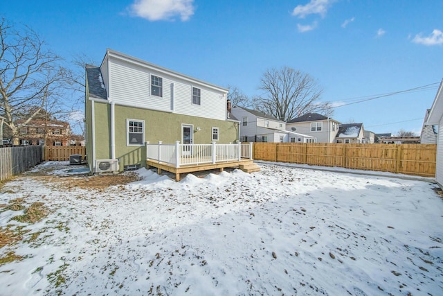 snow covered rear of property featuring a deck