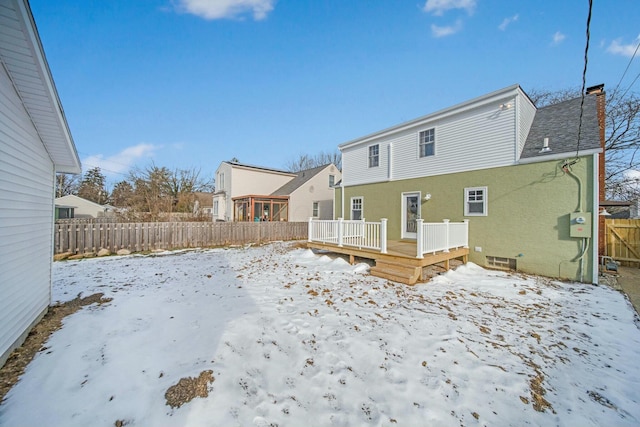 snow covered property with a wooden deck