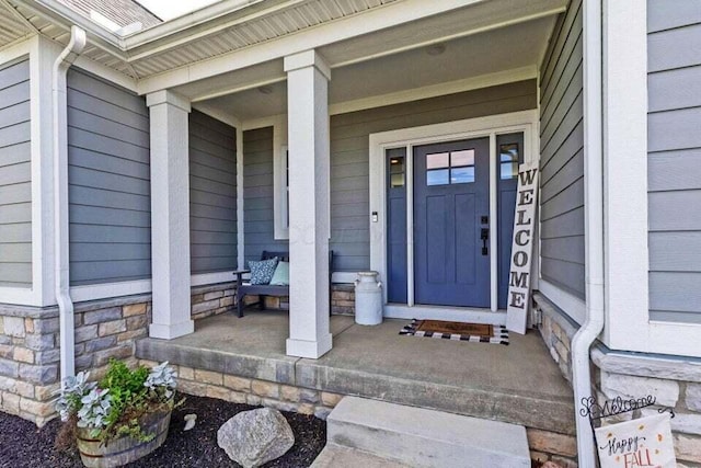 view of exterior entry featuring covered porch