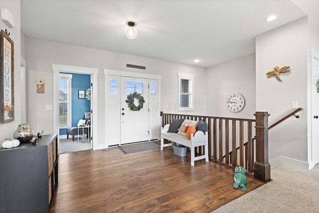 entryway with dark hardwood / wood-style flooring and a textured ceiling