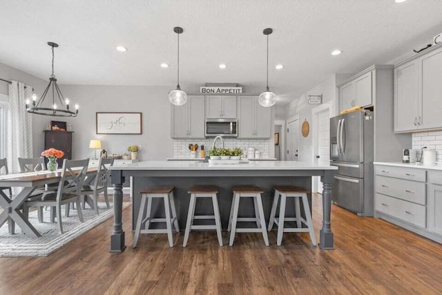 kitchen with decorative light fixtures, appliances with stainless steel finishes, and gray cabinets