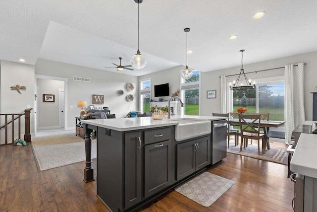 kitchen with dishwasher, a healthy amount of sunlight, sink, hanging light fixtures, and a kitchen island with sink