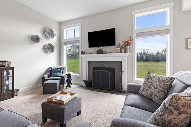 carpeted living room featuring a tiled fireplace