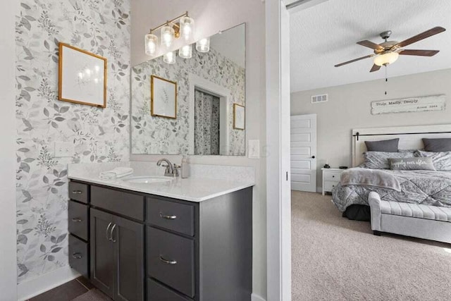 bathroom featuring ceiling fan, a textured ceiling, and vanity