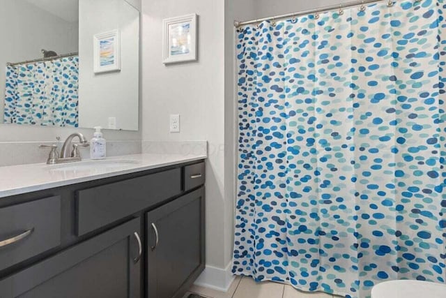 bathroom with toilet, vanity, walk in shower, and tile patterned flooring