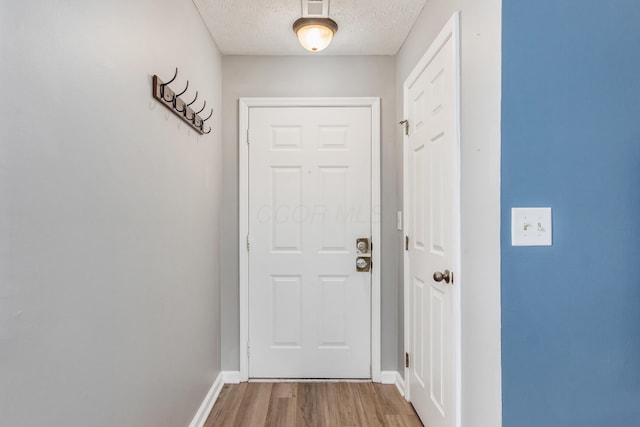 entryway with hardwood / wood-style flooring and a textured ceiling