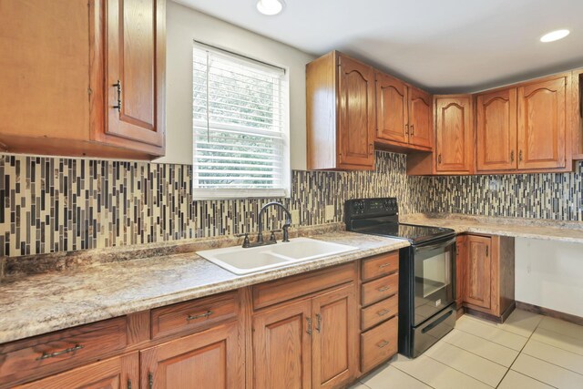 1973 Dartmouth Ave, Columbus, OH 43219 - kitchen featuring black range with electric stovetop, a sink, light tile patterned floors, light countertops, and tasteful backsplash