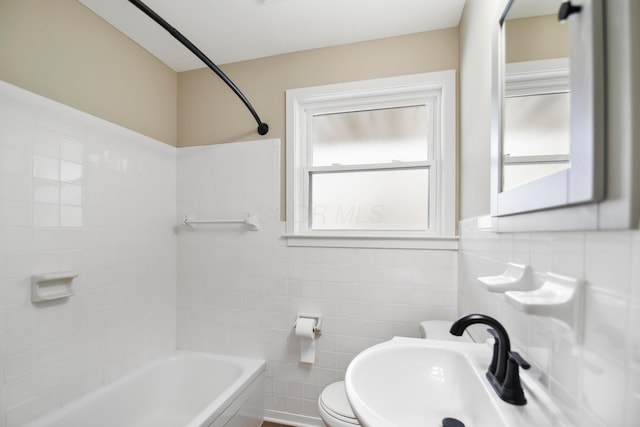 bathroom featuring sink, toilet, and tile walls