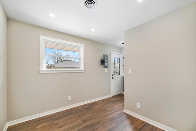 spare room featuring dark wood-type flooring and electric panel