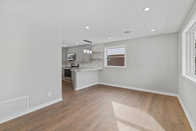 unfurnished living room with dark wood finished floors, recessed lighting, baseboards, and visible vents