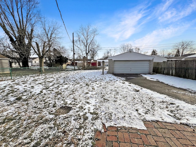 yard covered in snow featuring an outdoor structure and a garage