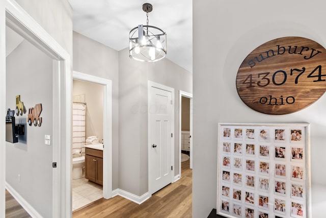 corridor featuring a chandelier and light hardwood / wood-style floors