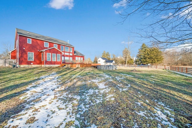 snow covered house featuring a yard