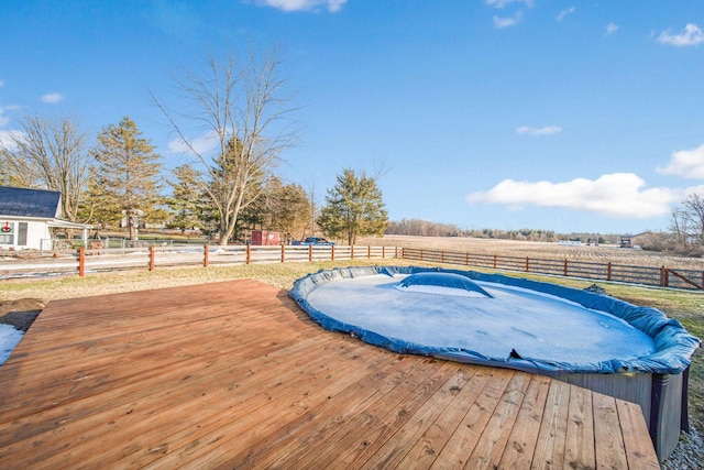 view of swimming pool featuring a rural view and a deck